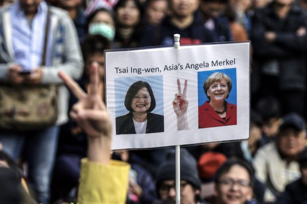 DPP giơ cao bức ảnh của bà Thái Anh Văn và Thủ tướng Đức Angela Merkel tại Đài Bắc hôm 15/1, dòng chữ có nội dung: “Thái Anh Văn - Angela Merkel của châu Á”. Ảnh: EPA.