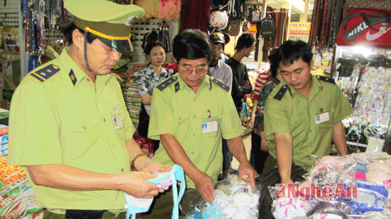 Cán bộ quản lý thị trường kiểm tra mẫu mã, chất lượng hàng tại chợ Vinh.