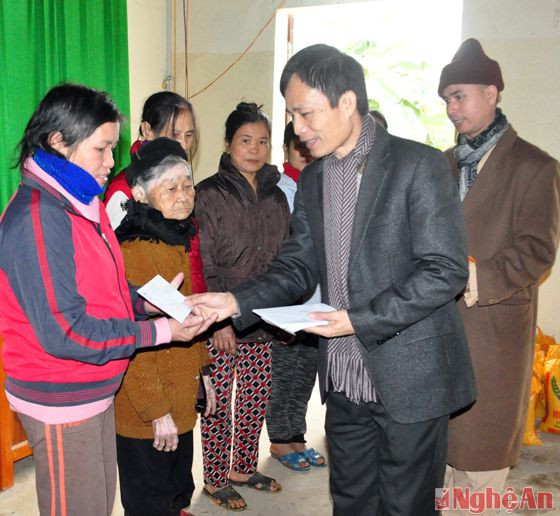 Phó Chủ tịch Ủy ban MTTQ tỉnh Võ Văn Tiến tặng quà cho các hộ nghèo tại xã Phong Thịnh, huyện Thanh Chương