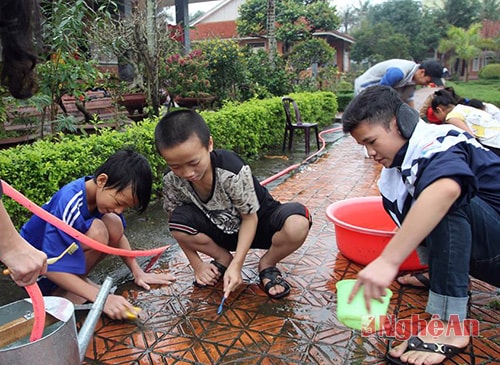 Các tình nguyện viên cùng các em nhỏ dọn vệ sinh chuẩn bị cho đêm hội.