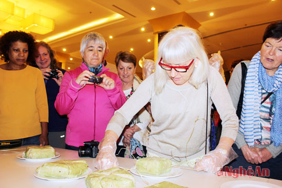 Các du khách được trực tiếp trải nghiệm cách bóc bánh chưng và thưởng thức hương vị món bánh chưng xanh cùng với dưa hành