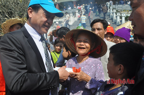 Đồng chí Lê Minh Thông - Phó Chủ tịch UBND tỉnh (người đội mũ xanh) trò chuyện và trao phần bánh chưng cho người dân địa phương