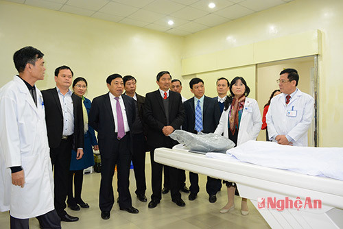 Đồng chí Nguyễn Xuân Đường nghe cán bộ y tế của bệnh viện giới thiệu về máy chụp CT 128 lát cắt.