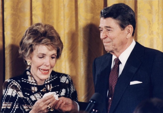 Khoảnh khắc Tổng thống Ronald Reagan đưa khăn tay cho vợ trong tiệc chia tay do nhân viên Nhà Trắng tổ chức hôm 18/1/1988. Ảnh: REUTERS/Leighton Mark.