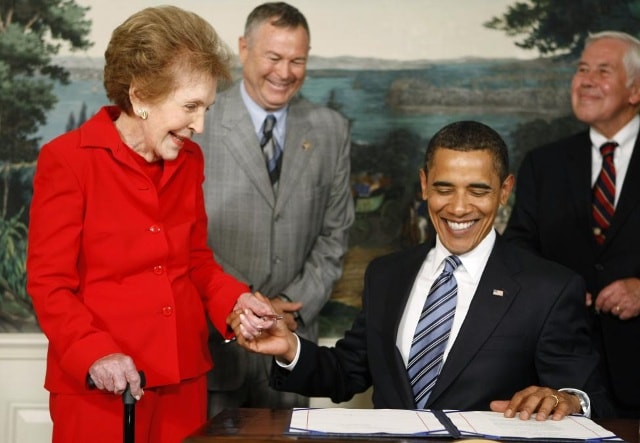 President Obama siết tay phu nhân Nancy Reagan sau khi phê duyệt kế hoạch kỷ niệm 100 năm ngày sinh Tổng thống Ronald Reagan, tại phòng Lễ tân Ngoại giao của Nhà Trắng hôm 2/6/2009. Ảnh: REUTERS/Kevin Lamarque.