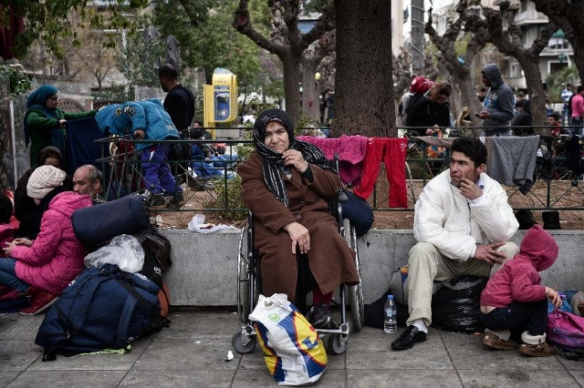 Một phụ nữ Afghanistan trên chiếc xe lăn, ngồi tại Quảng trường Victoria ở trung tâm Athens, nơi người tị nạn và di cư bị mắc kẹt, đành phải nương náu ở những trại trú ẩn tạm thời. Ảnh: AFP.