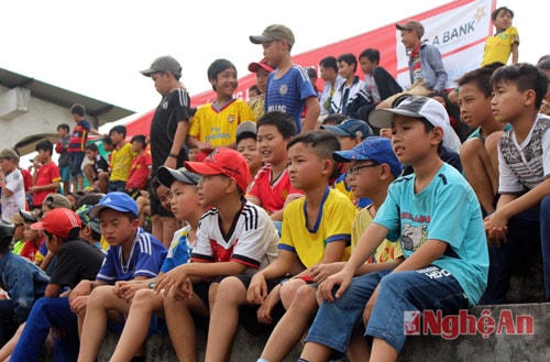Trên khán đài, các em nhỏ chú tâm theo dõi và