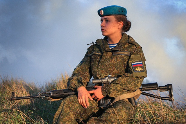 Nữ quân nhân ngay cả lúc ngồi nghỉ cũng không rời khẩu súng trường.
