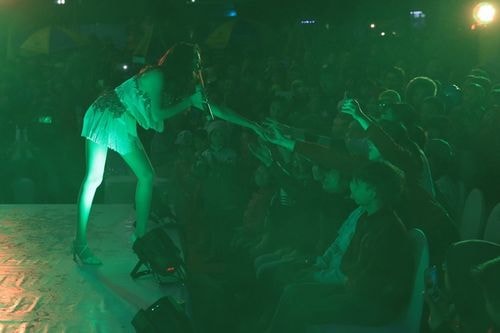 Cô tiến gần khán giả bắt tay thân thiện.