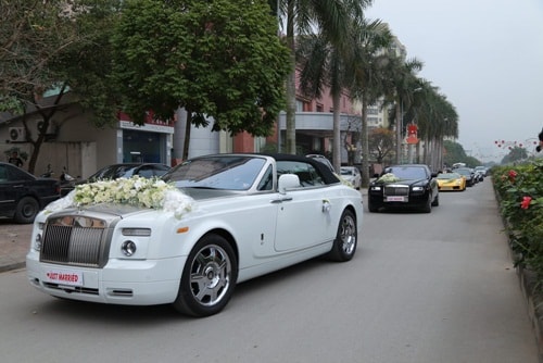 Cặp tân lang, tân nương ngồi trên xe Rolls-Royce Phantom mui trần 2 cửa màu trắng.