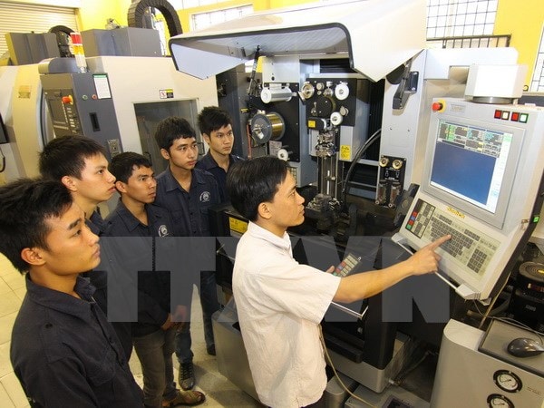 Giáo viên dạy nghề hướng dẫn học sinh thực hành. (Ảnh: Vũ Sinh/TTXVN)