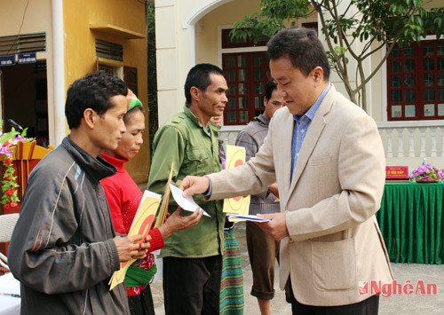 Đồng chí Lê Văn Giáp - Chủ tịch UBND huyện Quế Phong trao số tiền 500.000/ hộ, hỗ trợ sửa sang chuồng trại chăn nuôi.