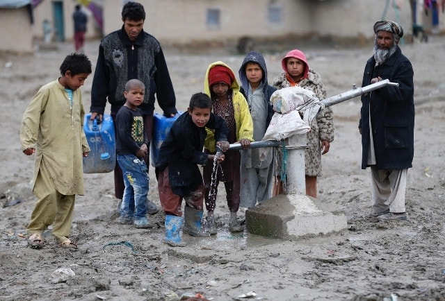 Những đứa trẻ uống nước từ máy bơm công cộng ở ngoại ô Kabul, Afghanistan.