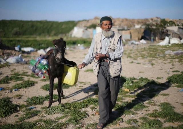 Người đàn ông Palestine dắt theo chú lừa chất đầy thùng và can rỗng trên lưng, bắt đầu chặng đường đi lấy nước ở Khan Younis, phía Nam Dải Gaza.