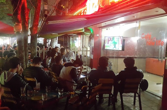 Dãy quán cafe nằm trên đường Đặng Văn Ngữ, Hà Nội là địa điểm không thể thích hợp hơn dành cho người yêu bóng đá. Rất nhiều fan hâm mộ, đặc biệt là các bạn sinh viên đã có mặt tại đây để cùng hòa chung không khí cổ vũ đội tuyển. Trong đó cũng có rất nhiều cổ động viên nữ. 