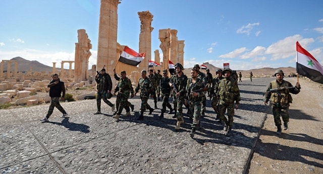 Quân đội Syria treo cờ trên nóc một tòa nhà mừng ngày giải phóng Palmyra.