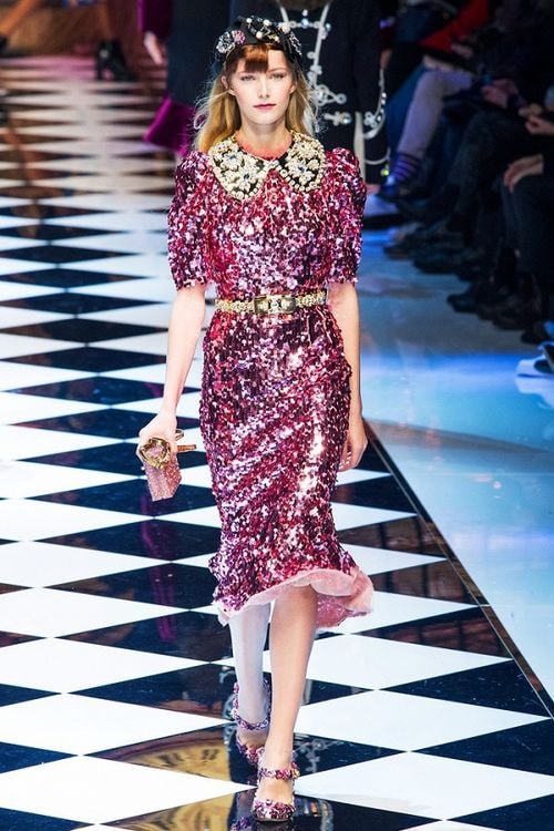 Dolce & Gabbana không dùng sắc màu chói lọi nhưng vẫn gây chú ý nhờ chi tiết đính kim sa dày đặc bắt sáng trên nền hồng fuchsia trầm.