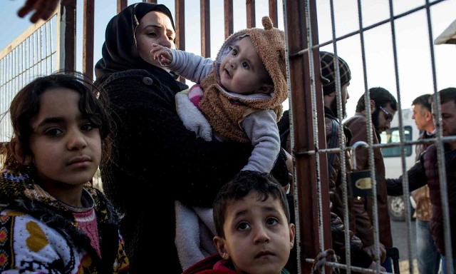 Người di cư Syria đứng đợi tại biên giới Thổ Nhĩ Kỳ ở Kilis hồi tháng 2. Ảnh: Getty Images.
