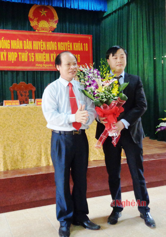 Đồng chí Hoàng Văn Phi - Bí thư Huyện ủy - Chủ tịch HĐND huyện tặng hoa chúc mừng tân Phó Chủ tịch.