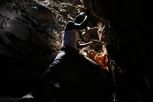 Nêm và thanh thép là công cụ lao động để phục vụ khai thác khoáng sản có chứa vàng. Trong ảnh: Người thợ làm việc ở độ sâu 30 m so với mặt đất tại một trong những điểm khai thác ở Macalder, huyện Migori, Tây Kenya hôm 29/2.