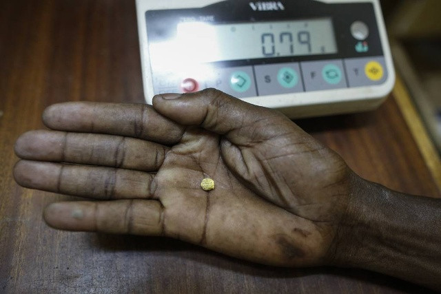 Thành quả cuối cùng. Một tay kinh doanh vàng “khoe” mẩu vàng thô nặng chừng 1 gam được bán với giá 31 USD trong cửa hàng tại Migori, Tây Kenya.