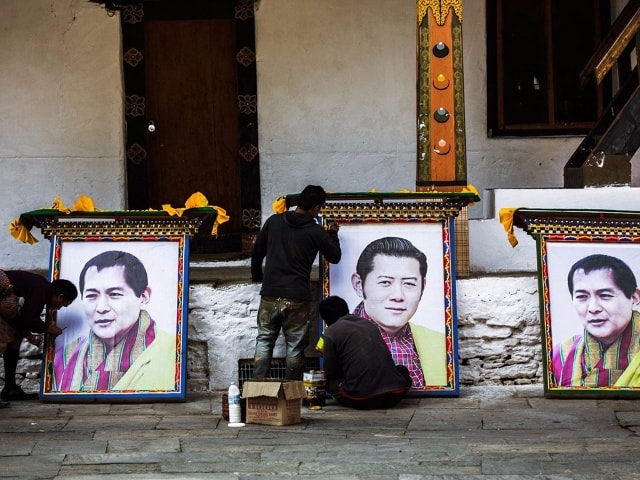 Vào những năm 1970, Bhutan không công nhận GDP (Tổng sản phẩm trong nước) là thước đo sự phát triển, mà quyết định sử dụng chỉ số GNP (Tổng hạnh phúc quốc gia). Vua Jigme Singye Wangchuck là người đưa ra quyết định này. Trong ảnh, các công nhân đang chuẩn bị chân dung của nhà vua và con trai ông, Vua Jigme Khesar Namgyel Wangchuck đương nhiệm.