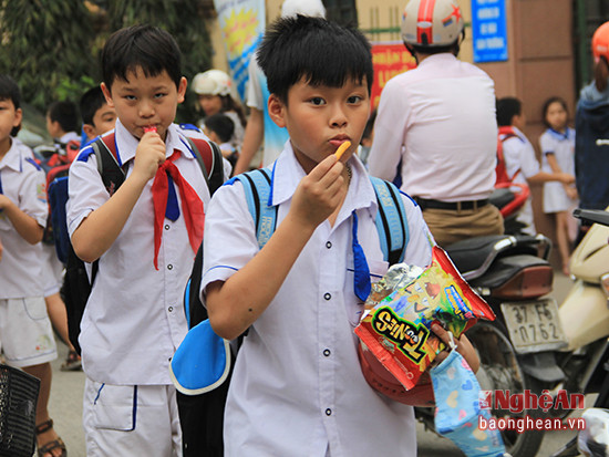 nhiều học sinh nam cũng ăn quà vặt cổng trường