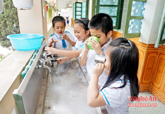 Học sinh Trường Tiểu học Hưng Lộc (TP. Vinh) uống nước qua xử lý bằng máy lọc.