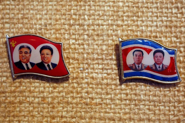 2 chiếc huy hiệu có in ảnh đồng thời của 2 cha con cố chủ tịch trong trang phục phương Tây và quân phục.