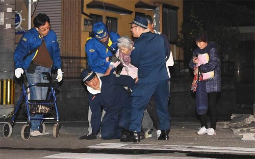 Các nhân viên cứu hộ đang trợ giúp một người già sau trận động đất ngày 14/4 ở Kumamoto, Nhật Bản - Ảnh: Bloomberg/Getty.