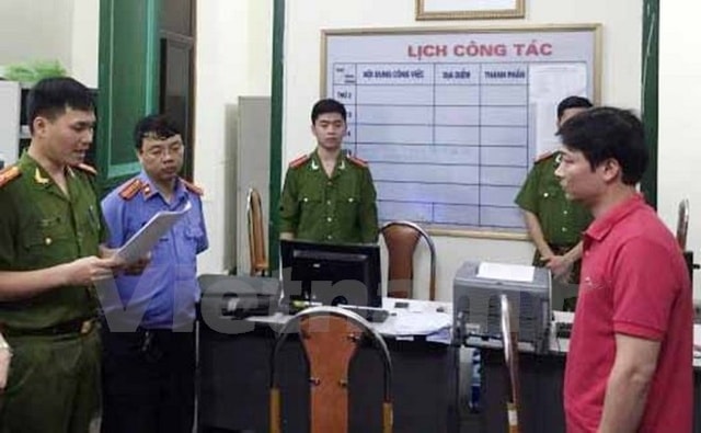 Công an đọc lệnh bắt tạm giam đối với ông Trần Hiếu. (Ảnh: Đoàn Minh Huệ/Vietnam+)