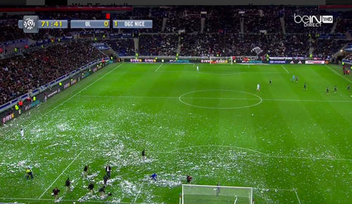 Một phần tư góc sân gần phía cầu môn Lyon bị phủ đầy giấy vụn.