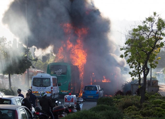 Ngọn lửa bốc cao trong vụ nổ xe buýt tại Jerusalem, Israel ngày 18/4. Ảnh: Reuters.