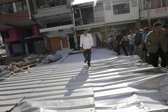 Tổng thống Ecuador - Rafael Correa bước đi giữa các mảnh vỡ dọc theo một con phố tại tỉnh Portoviejo.