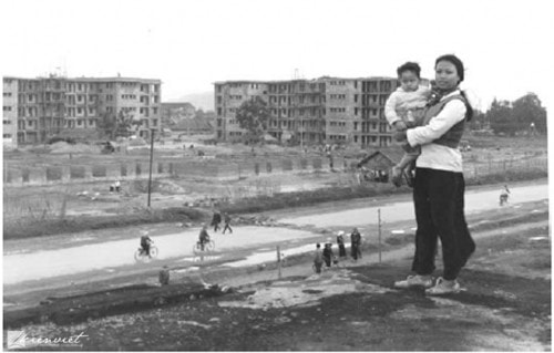 Khu chung cư Quang Trung năm 1974: Dự án nhà ở đầu tiên sau giải phóng từng và vẫn là niềm tự hào của Vinh, thể hiện trong ảnh người phụ nữ bế con lấy mặt tiền phía Tây của phố Quang Trung làm nền