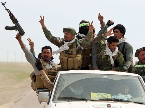 Iraqi Shiite fighters from the Popular Mobilization units sit in the back of a vehicle as they drive in the desert of Samarra, Iraq on March 3, 2016, during an operation aimed at retaking areas from the Islamic State.  Ahmad Al-Rubaye, AFP/Getty Images