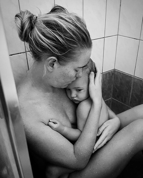 Bannister cởi quần áo của hai mẹ con rồi bế bé ngồi bệt xuống nền nhà tắm. Ảnh: Kelli Bannister.