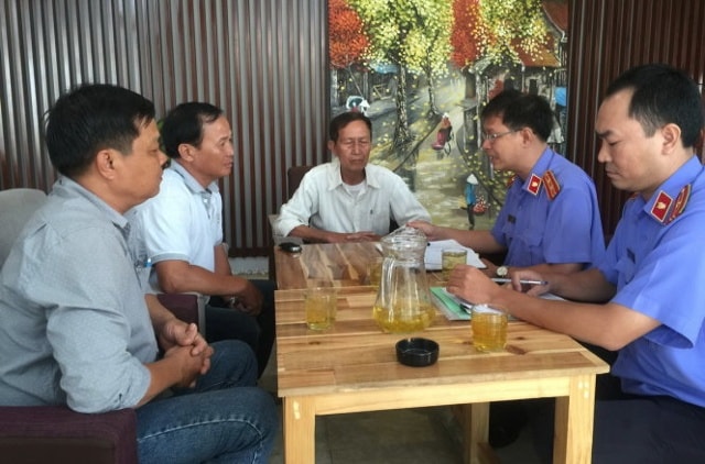 Đại diện VKSND huyện Bình Chánh đang chuẩn bị thủ tục trao quyết định đình chỉ vụ án, đình chỉ bị can với ông Tấn tại quán Xin Chào
