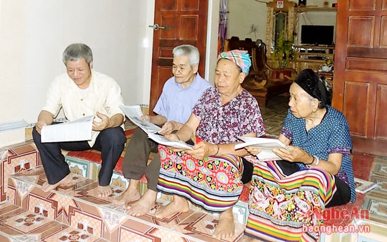 Ông Sầm Văn Bình (ngoài cùng bên trái) trao đổi cách truyền dạy chữ Thái cùng bà con dân bản.