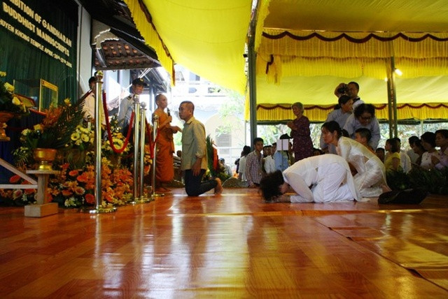 Phật tử quỳ lạy trước cổ vật kinh Phật trên lá bối. Ảnh: Điền Quang.