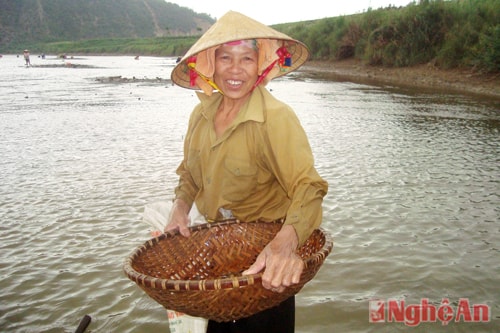 Bà Phạm Thị Quang (65 tuổi, xóm 4, Khánh Sơn 1) đang cào hến dưới sông vui vẻ cho biết: “Tui thường ra đây bắt hến, vừa kiếm thêm thức ăn, lại vừa vui. Dân làng ai cũng đi cả, ở đây vui hơn ở nhà”