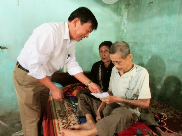 Ông Nguyễn Phi Long tặng quà cho hộ nghèo trong xóm.