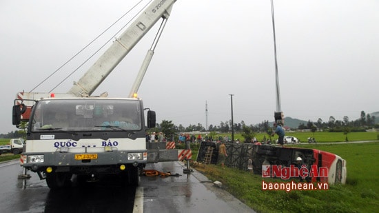 Lực lượng chức năng tiến hành cẩu xe khách lên, phân luồng đảm bảo giao thông,