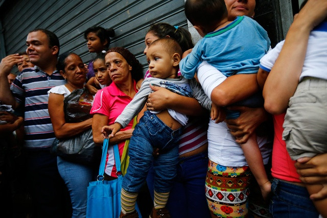 Người dân Venezuela phải xếp hàng để mua  nhu yếu phẩm tại siêu thị ở Caracas. Ảnh: Reuters.