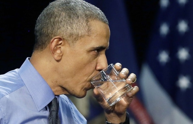 Tổng thống Obama uống nước trước sự chứng kiến của hàng nghìn người dân Flint, nơi đang diễn ra bê bối về nước nhiễm chì. Ảnh: AP,