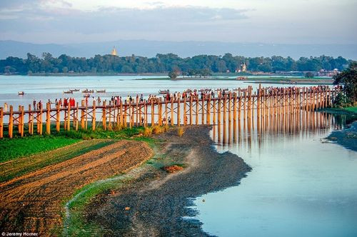 Các nhà sưu đi qua cây cầu U Bein, bắc ngang qua hồ Taungthaman gần Amarapura, Myanmar. Cây đầu xây năm 1850 được cho là cây cầu gỗ tếch lâu đời và dài nhất thế giới.