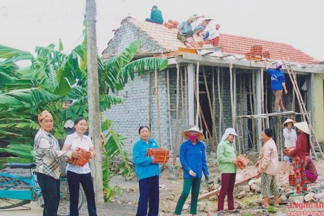 Chị Thường (áo trắng) cùng chị em phụ nữ hỗ trợ ngày công giúp hội viên nghèo làm nhà ở.