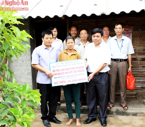 Đồng chí Phạm Quang Toản, Phó Bí thư Thường trực Thị ủy, Chủ tịch HĐND thị xã Thái Hòa (áo trắng bên phải) trao tiền hỗ trợ xây nhà cho chị Nguyễn Thị Hương, khối Dốc Cao, phường Quang Tiến