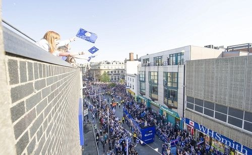 Các cầu thủ Leicester sốc với sự chào đón của các CĐV. Cửa hàng hai bên đường đều đóng cửa. Người dân leo lên cửa sổ, mái nhà chỉ để vẫy tay mừng khi các cầu thủ diễu hành ngang qua.