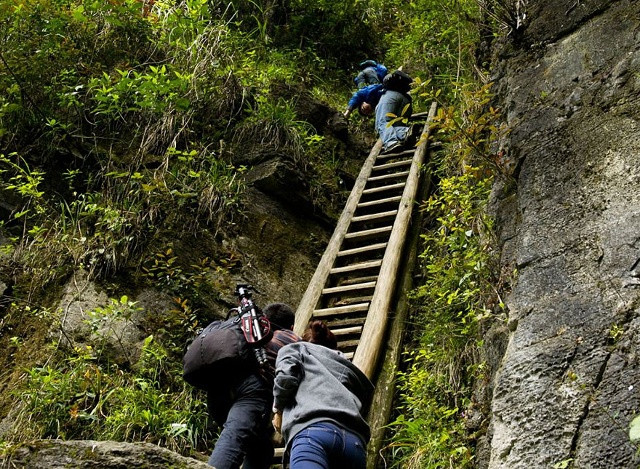 Học sinh ở làng Zhang Jiawan, miền NamTrung Quốc leo lên những chiếc thang gỗ không chắc chắn để đến trường. Ảnh: Rex Features.